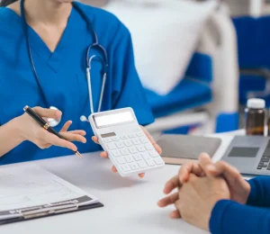 Doctor explaining Upper GI Endoscopy and Colonoscopy costs to a patient during a medical consultation.